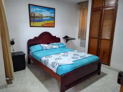 a bed in a bedroom with a picture on the wall at Hotel Tamaulipas Mixteca in Sincelejo