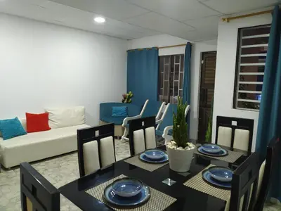 a dining room with a table and chairs and a couch at Casa Esmeralda in Cartagena de Indias