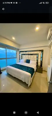 a bedroom with a large bed with a large window at Palmetto elíptic apto 3302 vista al mar in Cartagena de Indias