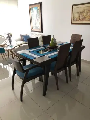 a dining room table with chairs and a laptop on it at Cartagena Espectacular apartamento en bocagrande in Cartagena de Indias