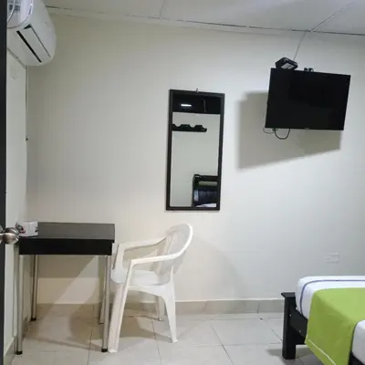 a room with a desk and a mirror and a chair at Hotel Villa Giron inn in Barranquilla