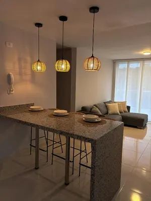 a kitchen with a large island in a living room at Apartamento La Plazuela Barranquilla in Barranquilla