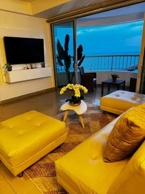 a living room with a yellow couch and a television at Alojamiento Cartagena frente Al Mar in Cartagena de Indias