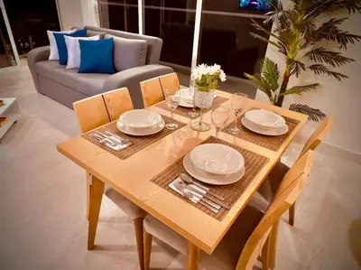 a wooden table with plates and wine glasses on it at Martinique Apto Private Jacuzzi - Netflix-Disney-Prime in Cartagena de Indias