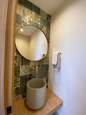 a bathroom with a round mirror on a wall at Casa frente a la playa in Salina de Rey