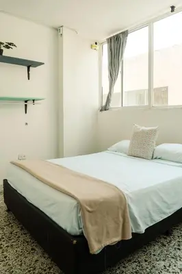 a large bed in a room with a window at MANGO BiCHE - HOUSE in Cartagena de Indias