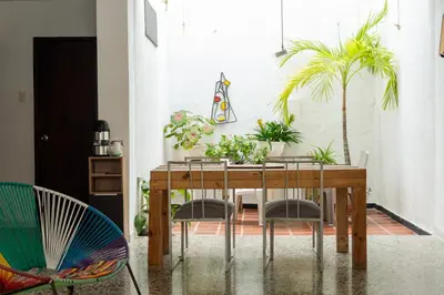 a dining room with a wooden table with plants on it at MANGO BiCHE - HOUSE in Cartagena de Indias