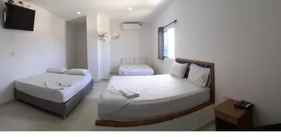 a bedroom with two beds and a television in it at Postel bar hotel in Cartagena de Indias