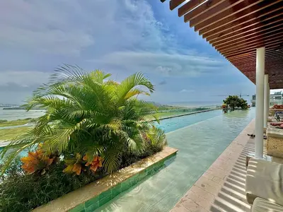 a swimming pool with a palm tree next to the ocean at Dominique 1101 - Espectacular Apto con Jacuzzi in Cartagena de Indias