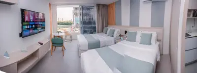 a hotel room with two beds and a tv at Porto Horizonte Suite 735 in Santa Marta