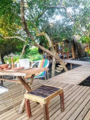 a wooden table and chairs on a wooden deck at Eywa Lodge in Pueblo Coco
