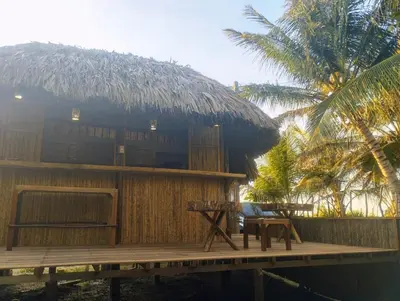 a hut with a table and a bench on a deck at Eywa Lodge in Pueblo Coco