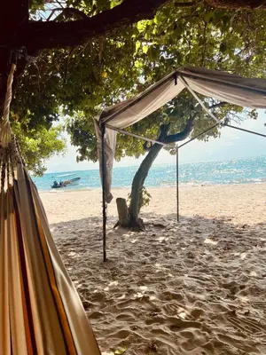 a tent on a sandy beach with the ocean at Cabaña OtraParte in Rincón