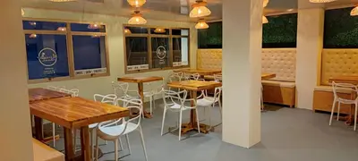 a restaurant with wooden tables and chairs and windows at Hotel Miramar Baru in Playa Blanca