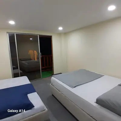 a bedroom with two beds and a living room with a couch at Hotel Miramar Baru in Playa Blanca