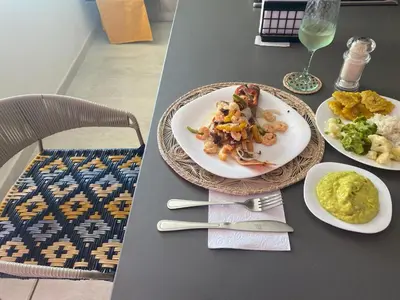 a table with two plates of food and a glass of wine at Caribbean Beachfront Getaway in Cartagena de Indias