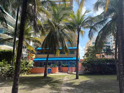 a group of palm trees in front of a building at Caribbean Beachfront Getaway in Cartagena de Indias