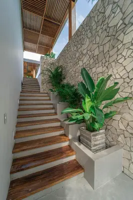 a set of stairs with potted plants next to a stone wall at Villa de lujo frente al mar en Tierra Bomba in Cartagena de Indias