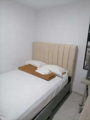 a bed with white sheets and pillows on it at Hostel AC in Cartagena de Indias