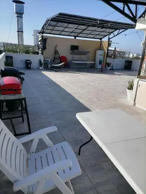 a patio with two white benches on a roof at Hostel AC in Cartagena de Indias