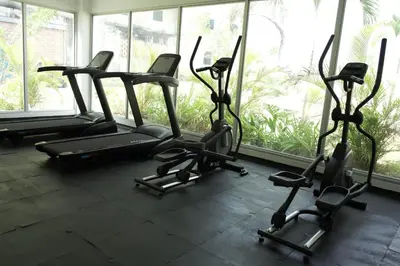 a gym with several cardio machines in a room with windows at BaiaKristal - Kabo en Cartagena in Cartagena de Indias