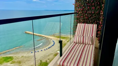 a balcony with a chair and a beach at Luxury Murano Cartagena Condo in Cartagena de Indias