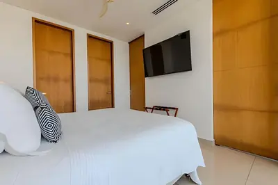 a bedroom with a white bed and a flat screen tv at Luxury H2 piso 19 / Sea Bay View & Historic Center in Cartagena de Indias