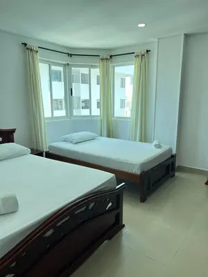 two beds in a room with two windows at Apartamento con vista al mar in Cartagena de Indias