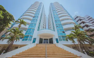 two tall buildings with palm trees in front of them at Apartamento con vista al mar in Cartagena de Indias