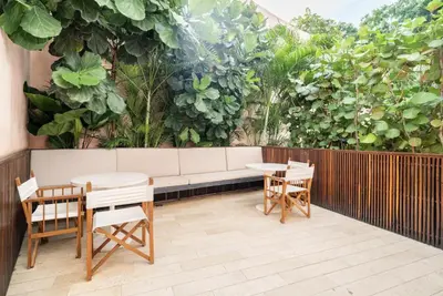 a patio with a couch and tables and plants at Sunny new apt in the Old City in Cartagena de Indias