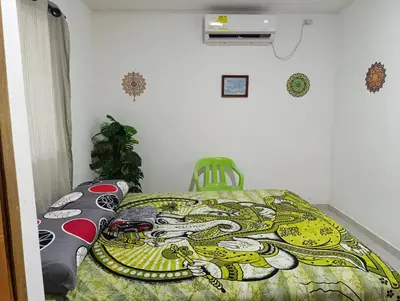 a bedroom with a bed with a comforter on it at Apartamento sereno, cerca al mar in El Porvenir