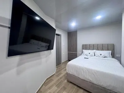 a bedroom with a bed and a flat screen tv at Hospedaje Casa Rueda in Barranquilla