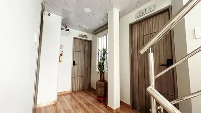 a hallway with two wooden doors and a potted plant at Hospedaje Casa Rueda in Barranquilla