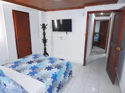 a bedroom with a bed and a tv on the wall at Apartment Nurita Boston in Barranquilla