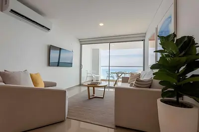 a living room with a couch and a plant at Modern 2BR next to the Walled City+Oceanside View in Cartagena de Indias