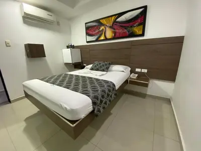 a bedroom with a bed and a painting on the wall at Los Prados Vip in Barranquilla