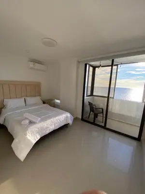 a bedroom with a bed and a view of the ocean at LIVING CARTAGENA Apto de lujo in Cartagena de Indias