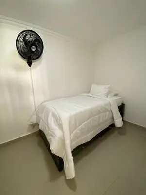 a white bedroom with a bed and a fan at LIVING CARTAGENA Apto de lujo in Cartagena de Indias