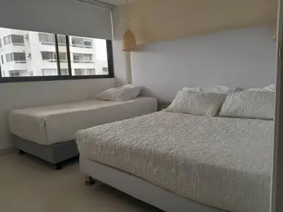 a bedroom with two beds and a window at Gloria Al Laguito Duplex in Cartagena de Indias