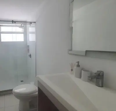 a white bathroom with a toilet and a sink at Gloria Al Laguito Duplex in Cartagena de Indias