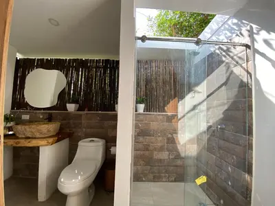 a bathroom with a toilet and a glass shower at Casa de playa Kommox Beach in Cartagena de Indias