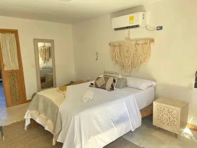a bedroom with a large white bed and a heater at Casa de playa Kommox Beach in Cartagena de Indias