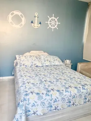 a bedroom with a bed with a blue wall at Apartamento Acogedor en Cartagena in Cartagena de Indias