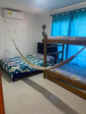 a bedroom with two bunk beds and a hammock at Cabaña la casa de vero in Santa Veronica