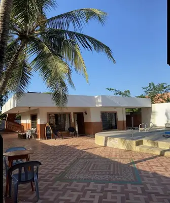 a building with a palm tree in front of it at Cabaña la casa de vero in Santa Veronica