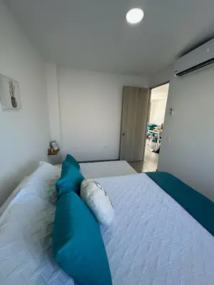 a bedroom with a bed with blue pillows on it at 203 Apartamento Frente al Mar in San Bernardo del Viento