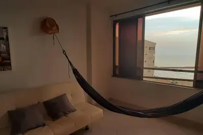 a hammock in a living room with a window at Cómodo Ap Frente al mar, cerca a la murallas in Cartagena de Indias
