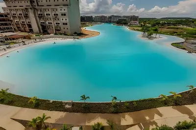 a large pool with blue water in the middle at Lujoso A Estrenar/Oasis Laguna Cristalina 2BR in Los Arrayanes