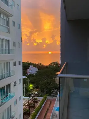 a sunset seen from a balcony of a building at Bello Horizonte Suite in Santa Marta