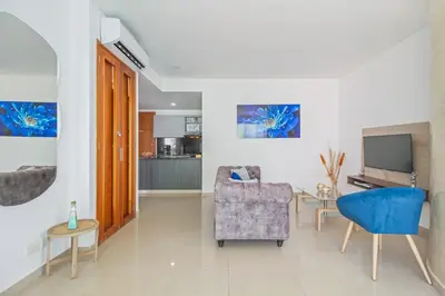 a living room with a blue chair and a television at Vista de lujo al mar y la bahía in Cartagena de Indias